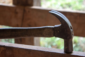 Old hammer on top of a wooden fence