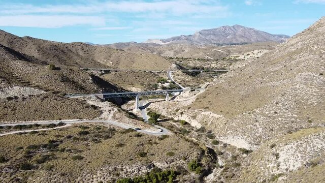 Vista A&eacute;reas de l&iacute;nea f&eacute;rrea entre monta&ntilde;as en zona semides&eacute;rtica en Espa&ntilde;a