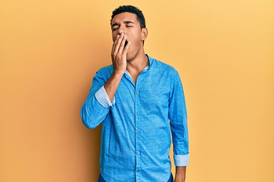 Young arab man wearing casual clothes bored yawning tired covering mouth with hand. restless and sleepiness.