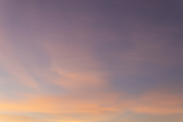 Blue sky with pink and yellow cirrus clouds just before sunset
