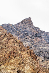 Massive rocky mountain in Provo Canyon Utah with cloudy sky in the background
