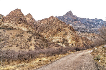 Fototapeta na wymiar Road along a massive rocky mountain in Provo Canyon Utah against cloudy sky view