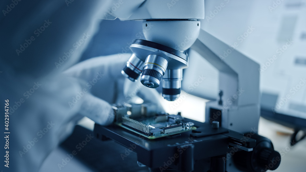 Aufkleber Research Factory Cleanroom: Close-up of Engineer / Scientist wearing Coverall and Gloves Use Microscope to Inspect Motherboard Microprocessor Component, Developing High Tech Modern Electronics