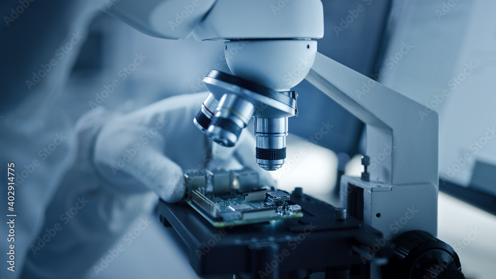 Poster Research Factory Cleanroom: Close-up of Engineer / Scientist wearing Coverall and Gloves Use Microscope to Inspect Motherboard Microprocessor Component, Developing High Tech Modern Electronics