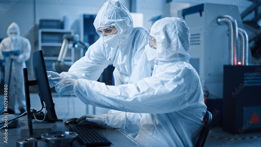 Aufkleber Factory Cleanroom: Engineer and Scientist Wearing Coveralls and Masks Have Discussion, Use Computer Showing Infrastructure System Control. In Background CNC Machinery, Robot Arm, Electronics Equipment