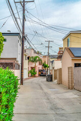 Houses and electricity posts along narrow neighborhood street in Long Beach CA