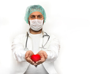 Portrait of male doctor in white coat wearing white mask and holding heart sign. Stethoscope on the neck. Isolated on white background. Healthcare And Medicine. Heart disease prevention concept.