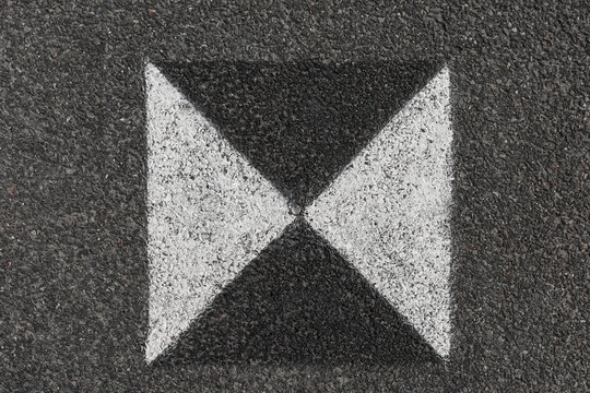Photograph of a generic black and white fiducial marker (sometimes used in construction for calibration) shot from above.