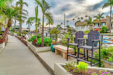 Walkway lined with palm trees and chairs with spectacular view of the canal