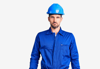 Young handsome man wearing worker uniform and hardhat tired rubbing nose and eyes feeling fatigue and headache. stress and frustration concept.