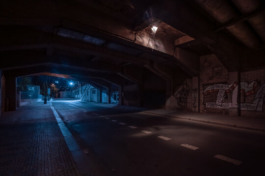 Dark empty dirty grunge underground concrete tunel with a road during mystic night with blue street lights