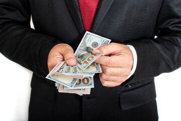 Closeup of businessman's hands counting US dollars bills. Man counting bunch of money on white background. Spending, saving, earning money concept. Getting salary. Company profit, investment earnings.