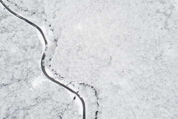 Aerial view of a road in the middle of the white forest