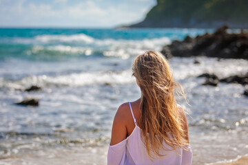 Young beautiful girl by the sea with developing hair