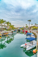 Fototapeta na wymiar Boats docked on canal of a picturesque neighborhood in Long Beach California