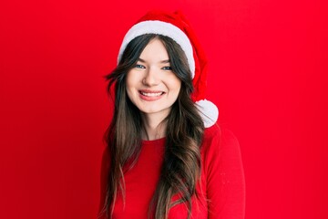 Young beautiful caucasian girl wearing christmas hat looking positive and happy standing and smiling with a confident smile showing teeth