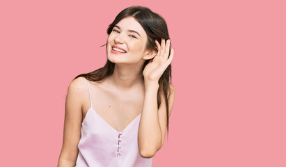 Fototapeta premium Young beautiful caucasian girl wearing casual clothes smiling with hand over ear listening an hearing to rumor or gossip. deafness concept.