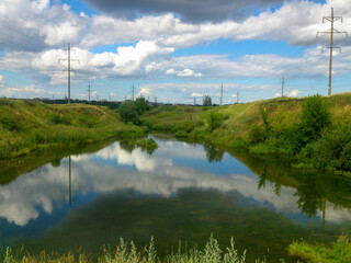 summer nature on the lake against the blue sky with clouds