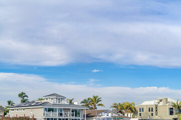 Picturesque skyscape of blue sky and clouds over beautiful waterfront houses