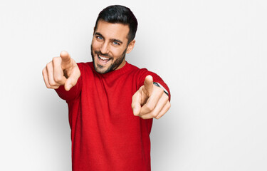 Young hispanic man wearing casual clothes pointing to you and the camera with fingers, smiling positive and cheerful - obrazy, fototapety, plakaty