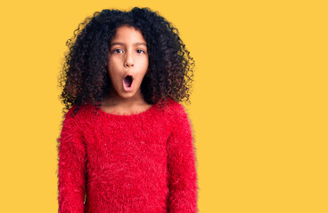 African american child with curly hair wearing casual winter sweater scared and amazed with open mouth for surprise, disbelief face