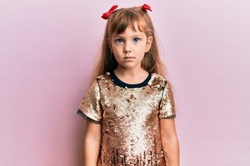 Little caucasian girl kid wearing festive sequins dress relaxed with serious expression on face. simple and natural looking at the camera.