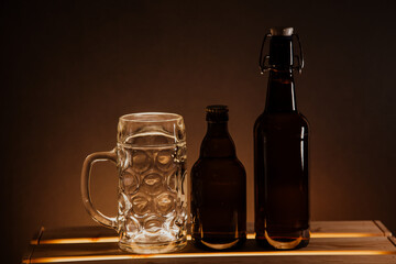 empty beer bottle on a wooden table and a glass of beer