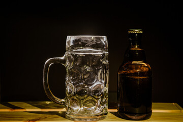 macro beer bottle and a glass of beer on a dark