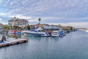 Fototapeta na wymiar Leisure watercrafts on private docks of houses in Huntington Beach California