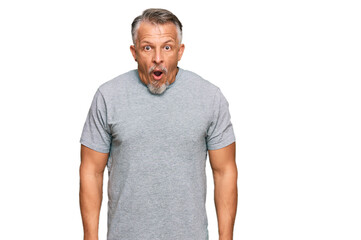 Fototapeta premium Middle age grey-haired man wearing casual clothes scared and amazed with open mouth for surprise, disbelief face