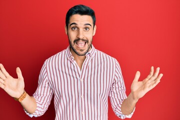 Young hispanic man wearing business shirt celebrating victory with happy smile and winner expression with raised hands