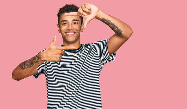 Young handsome african american man wearing casual clothes smiling making frame with hands and fingers with happy face. creativity and photography concept.