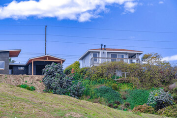 Fototapeta na wymiar House and garage on a slope against blue sky background in San Diego California