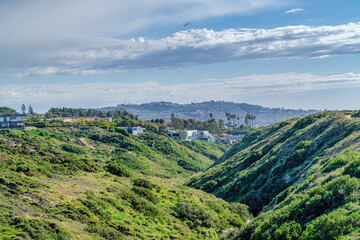Mountain covered with greenery against cloudy blue sky in San Diego California