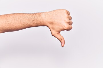Close up of hand of young caucasian man over isolated background doing thumbs down rejection gesture, disapproval dislike and negative sign