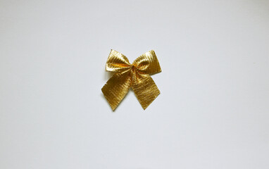 Single golden shiny gift bow on white background. Top view.