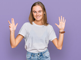 Beautiful young blonde woman wearing casual white t shirt showing and pointing up with fingers...