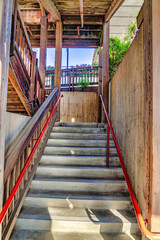 Close up of wooden stairway with wood and metal handrails on a sunny day