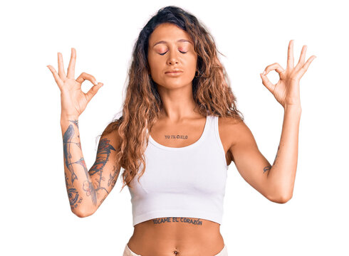 Young Hispanic Woman With Tattoo Wearing Casual Clothes Relax And Smiling With Eyes Closed Doing Meditation Gesture With Fingers. Yoga Concept.