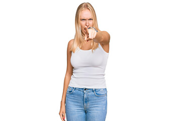 Young blonde girl wearing casual style with sleeveless shirt pointing displeased and frustrated to the camera, angry and furious with you