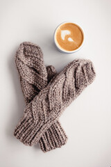 mitten, mug cappuccino on white table