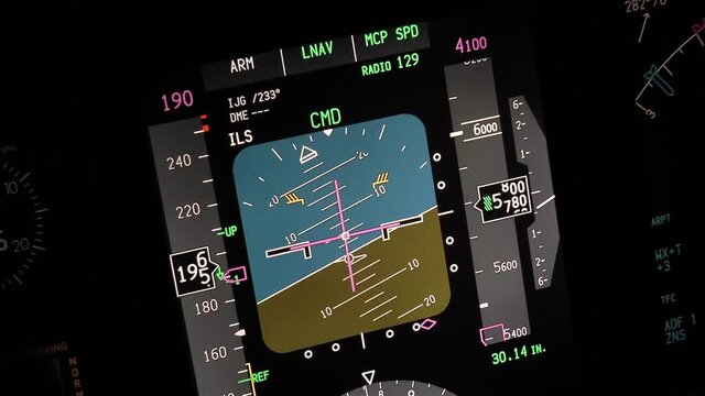 Flight instruments display of a modern passenger airplane flying at night. Actual cockpit footage. Aircraft is slowing down, turning and descending for landing.