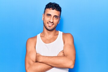 Young hispanic man wearing casual clothes happy face smiling with crossed arms looking at the camera. positive person.