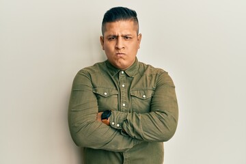 Obraz premium Young latin man wearing casual clothes skeptic and nervous, disapproving expression on face with crossed arms. negative person.