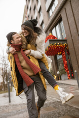 Happy cheerful and young caucasian couple are having fun while dating together outdoors in a city