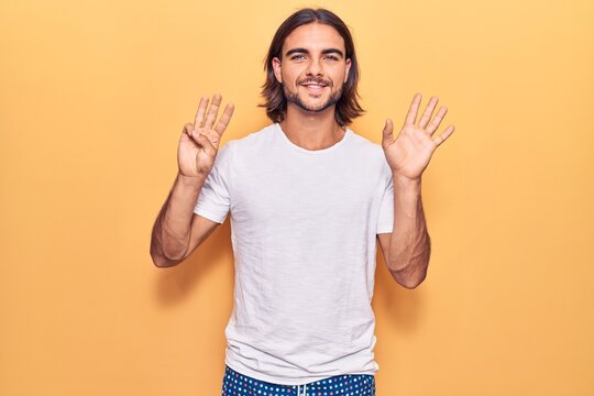 Young handsome man wearing casual clothes showing and pointing up with fingers number eight while smiling confident and happy.