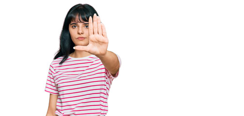 Young hispanic girl wearing casual clothes doing stop sing with palm of the hand. warning...
