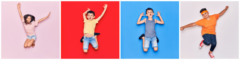Group of children jumping happy and crazy over colorful background at studio