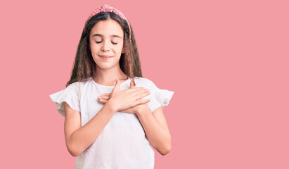 Cute hispanic child girl wearing casual white tshirt smiling with hands on chest with closed eyes and grateful gesture on face. health concept.