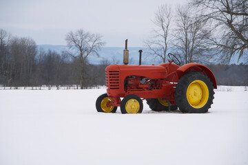 A red tractor in a snow filled farmers field